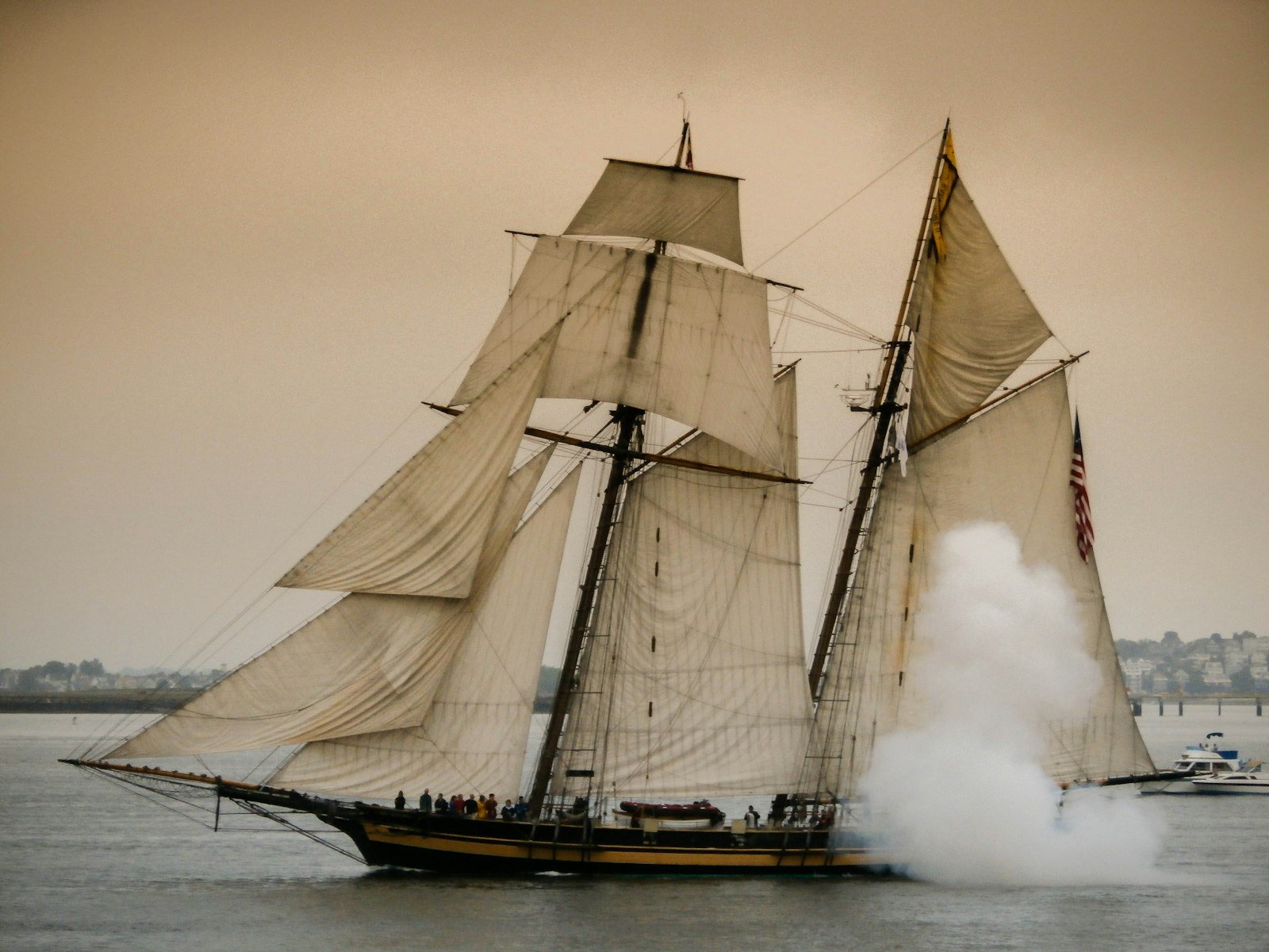 A square-rigged sailing ship under a grey sky on the open ocean